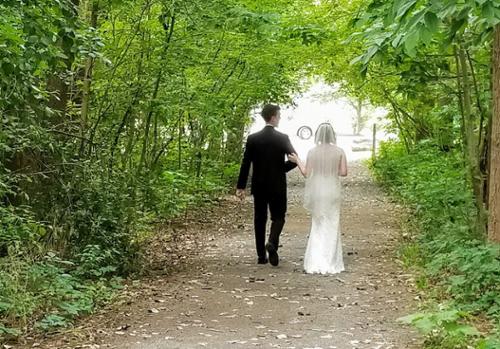 A couple walks through the natural arbor within the Burchfield Nature Center.