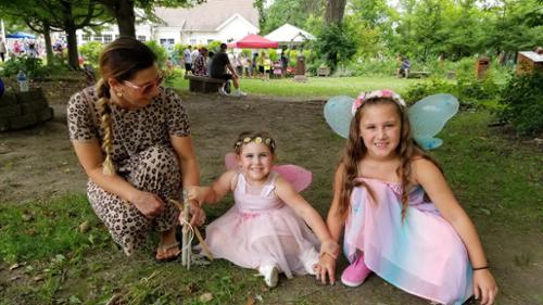 Enchanted forest brings out children in winged costumes, enjoying the summer activities.